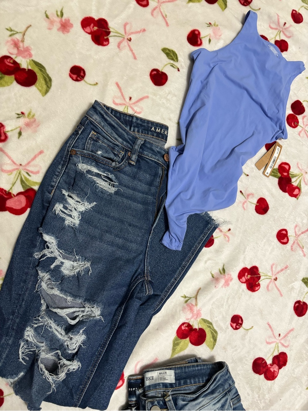 SKIMS Periwinkle Blue Bodysuit with Distressed Dark Blue Jeans